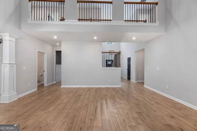 an empty room with windows and fan