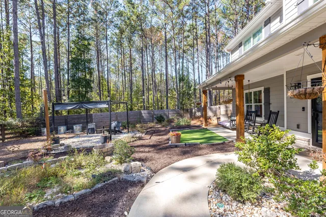 a view of a chair and fire pit in the backyard with large trees