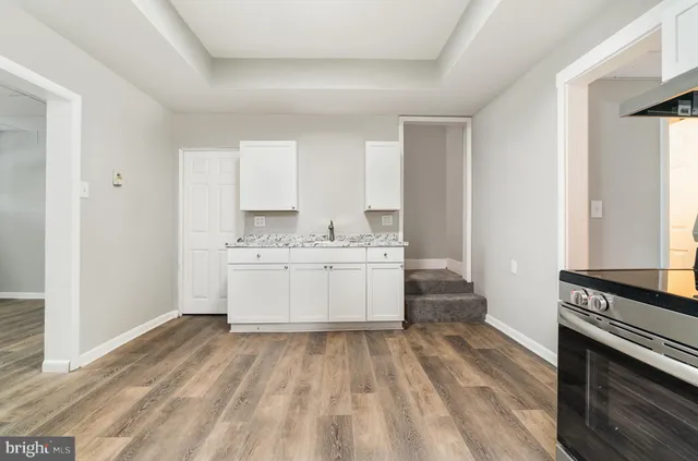 a view of a kitchen with wooden floor and electronic appliances