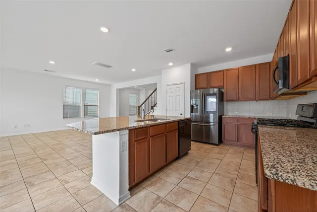 a kitchen with stainless steel appliances a sink and cabinets