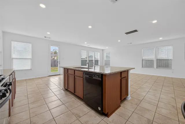 a kitchen with stainless steel appliances granite countertop a stove top oven a sink and a refrigerator