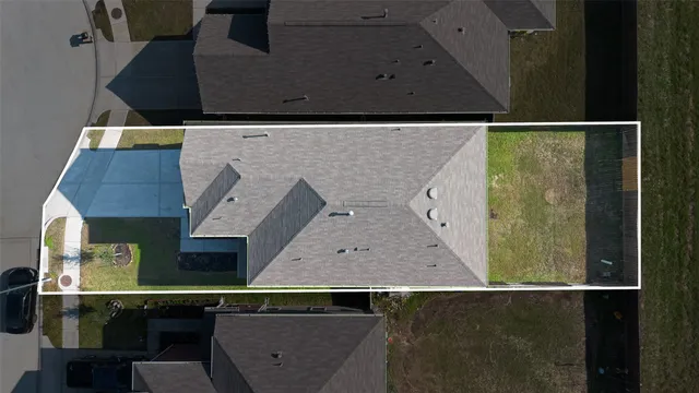 an aerial view of a residential houses with outdoor space and parking