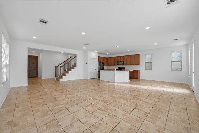 a view of an empty room with window and hardwood floor