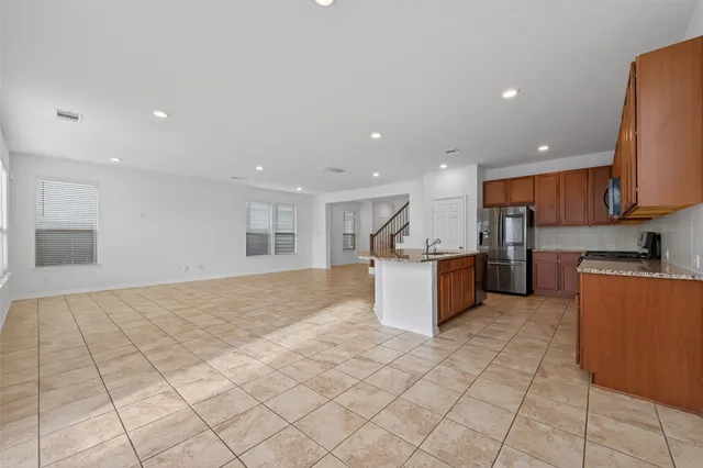 a kitchen with stainless steel appliances granite countertop a refrigerator and a sink