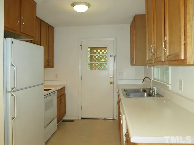 a kitchen with a refrigerator a sink and cabinets