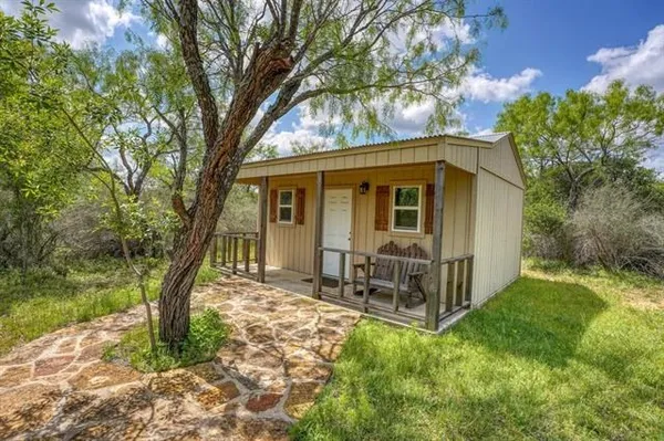 a view of a house with backyard and a tree