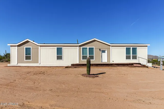 a view of a house with a patio and a yard