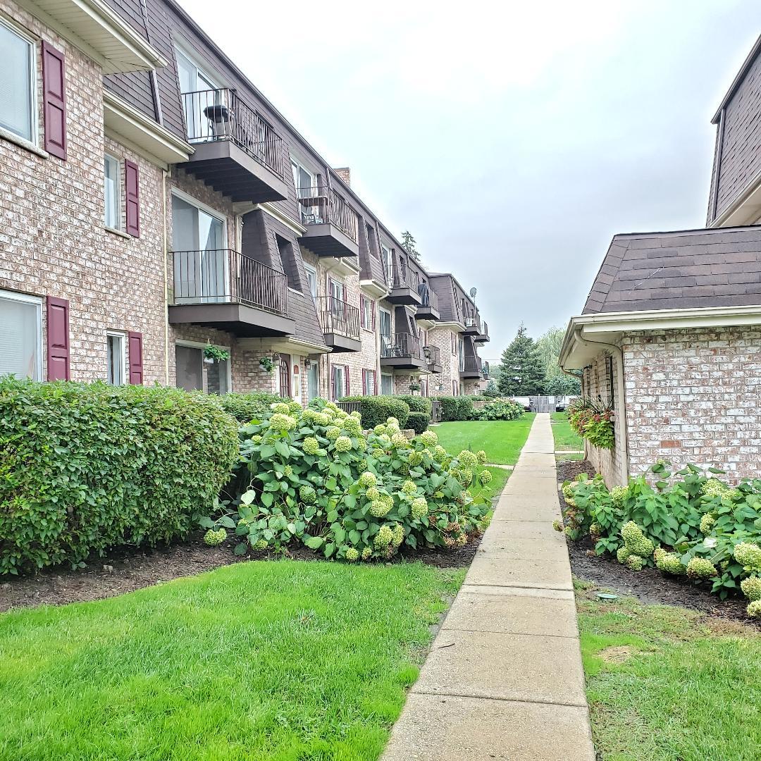 912 South Plum Grove Road, Unit 122 Palatine, IL 60067 - Photo 4 of 18 a front view of a building with a yard