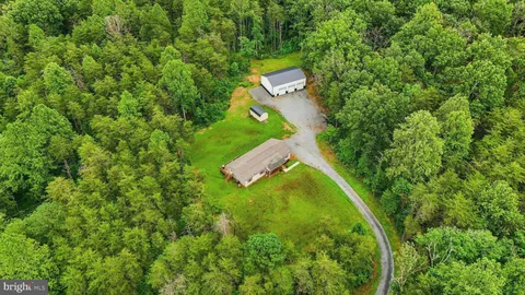 an aerial view of a house with a yard and trees