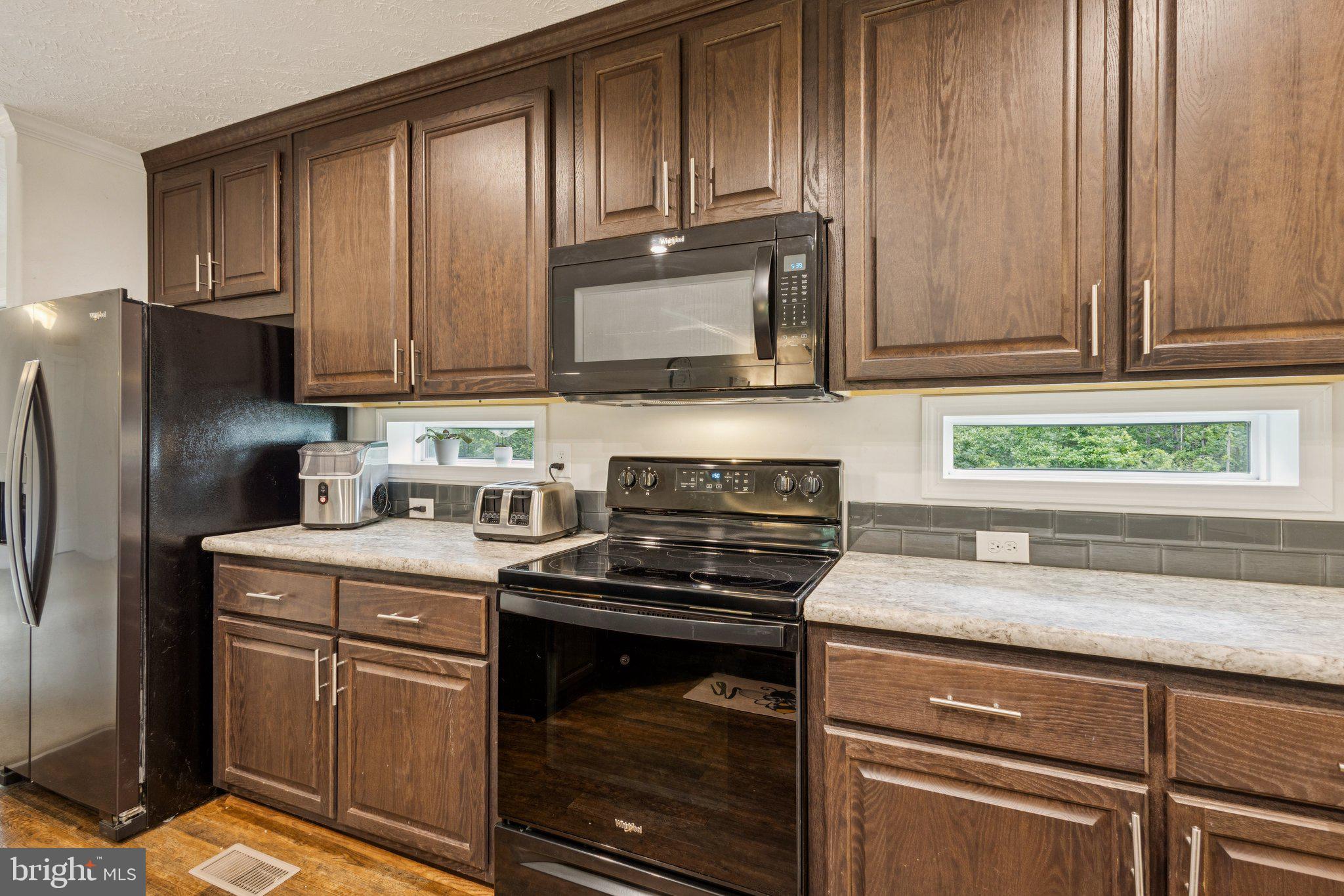 13153 Stonehouse Mountain Road Culpeper, VA 22701 - Photo 10 of 45 a kitchen with granite countertop wooden cabinets and a stove top oven