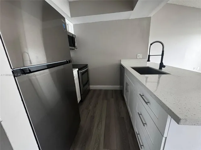 a kitchen with a refrigerator and a sink