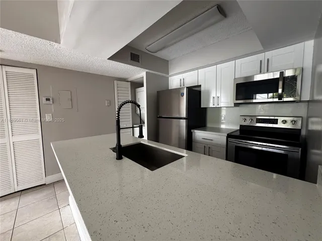 a kitchen with stainless steel appliances a refrigerator a stove a microwave and cabinets