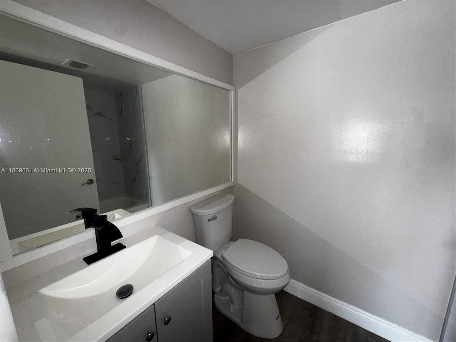 5780 Rock Island Road, Unit 375 Tamarac, FL 33319 - Photo 3 of 26 a bathroom with a sink a toilet and mirror