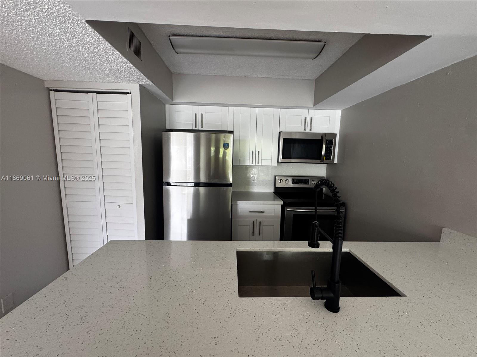 5780 Rock Island Road, Unit 375 Tamarac, FL 33319 - Photo 9 of 26 a kitchen with a refrigerator and a stove top oven