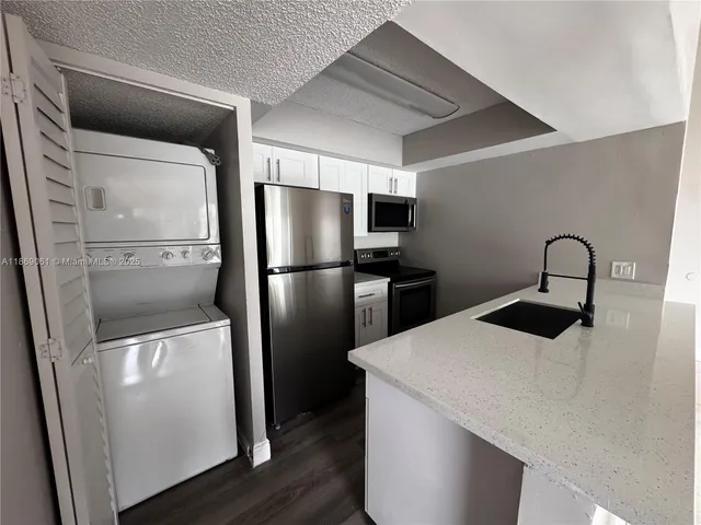 a kitchen with a refrigerator and a sink