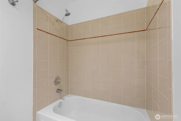 a bathroom with a white bath tub and a shower in a bathroom