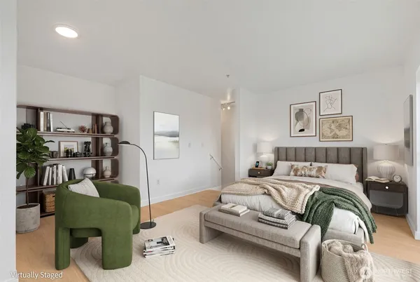 a bedroom with a bed a couch and lots of books