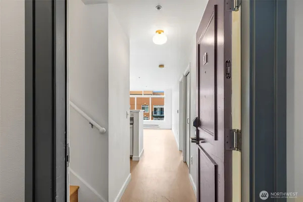 a view of a hallway with wooden floor and glass door
