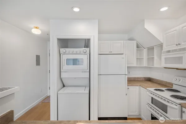 a kitchen with a refrigerator stove and white cabinets