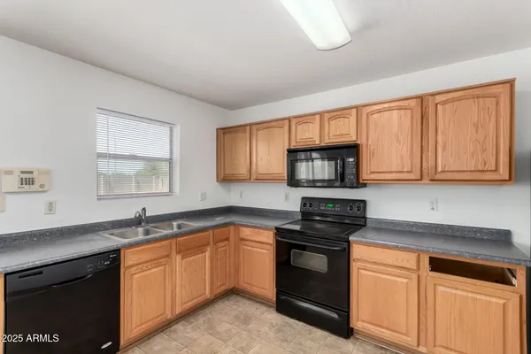 a kitchen with granite countertop white cabinets and stainless steel appliances
