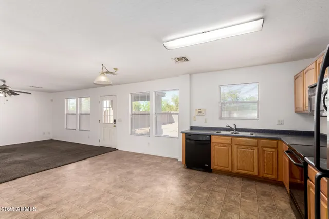 a large kitchen with kitchen island a sink large window and stainless steel appliances