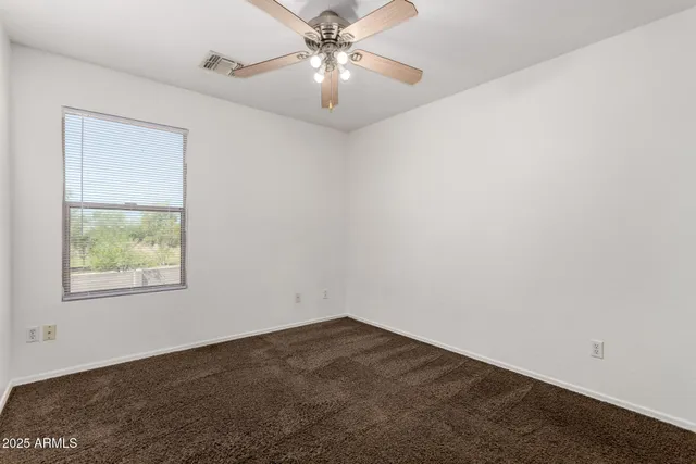 an empty room with a ceiling fan and a bathroom