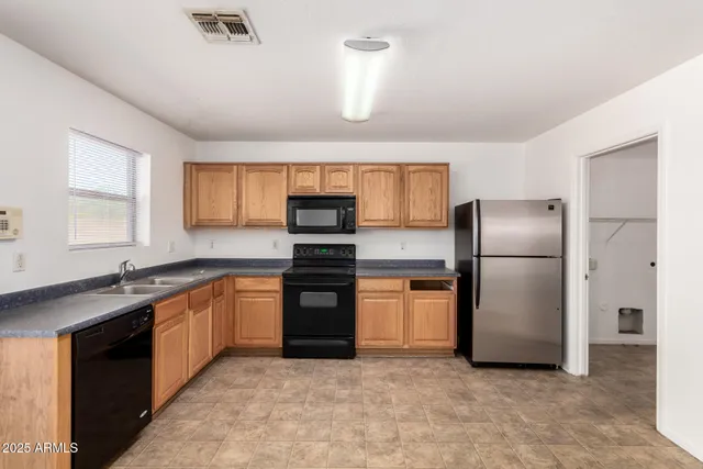 a kitchen with stainless steel appliances granite countertop a refrigerator a sink a stove and dishwasher