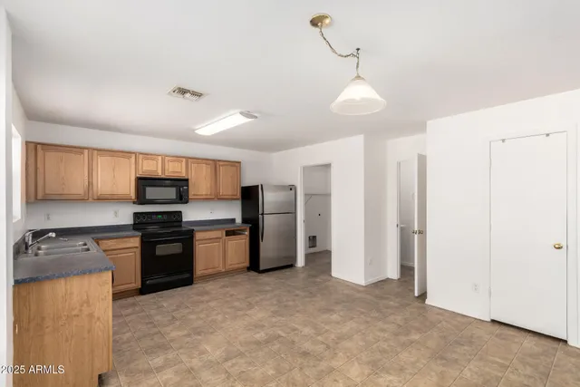 a kitchen with stainless steel appliances granite countertop a refrigerator stove top oven and sink