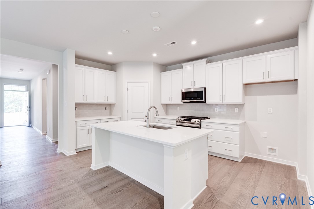 0 Canoe Pointe Loop Moseley, VA 23120 - Photo 4 of 15 a kitchen with white cabinets and stainless steel appliances