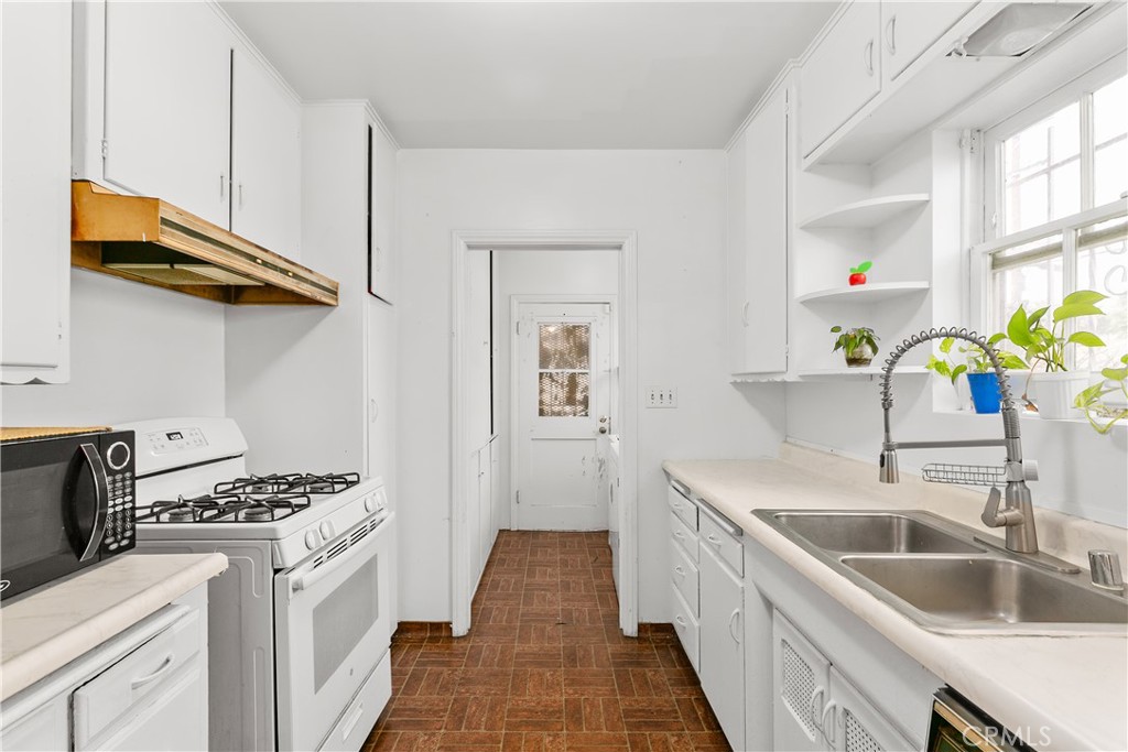 1615 North Van Ness Avenue Compton, CA 90221 - Photo 16 of 36 a kitchen with stainless steel appliances granite countertop a sink stove and refrigerator