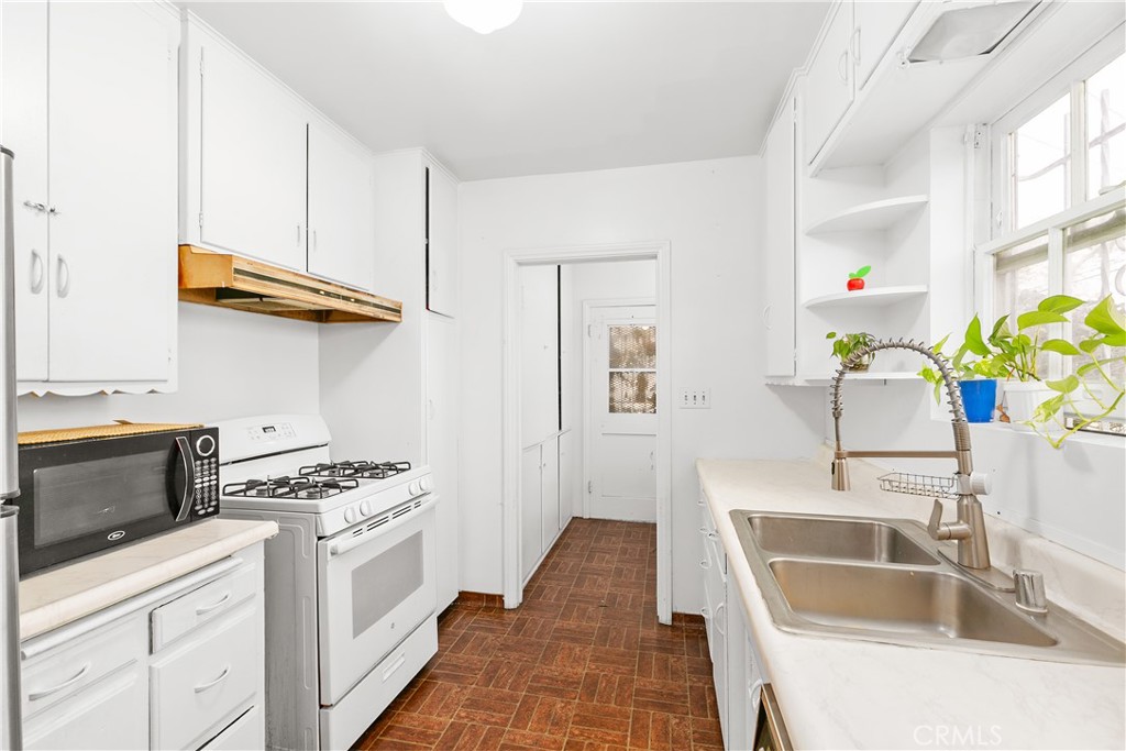 1615 North Van Ness Avenue Compton, CA 90221 - Photo 17 of 36 a kitchen with stainless steel appliances a sink a stove and cabinets