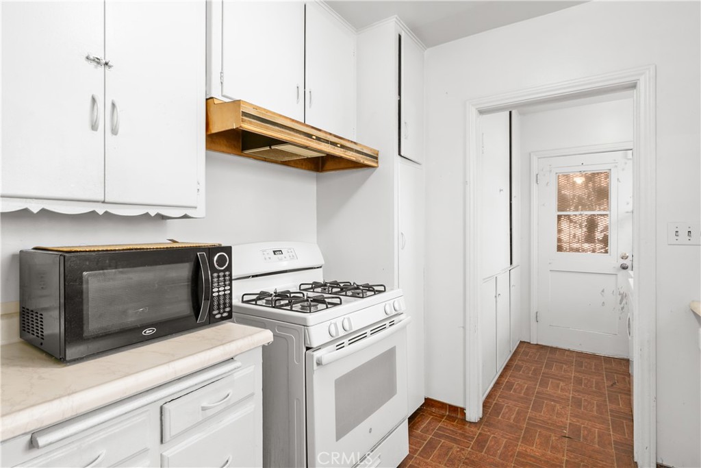 1615 North Van Ness Avenue Compton, CA 90221 - Photo 18 of 36 a kitchen with stainless steel appliances a stove and a microwave