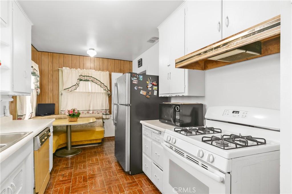 1615 North Van Ness Avenue Compton, CA 90221 - Photo 21 of 36 a kitchen with a stove a refrigerator and a sink