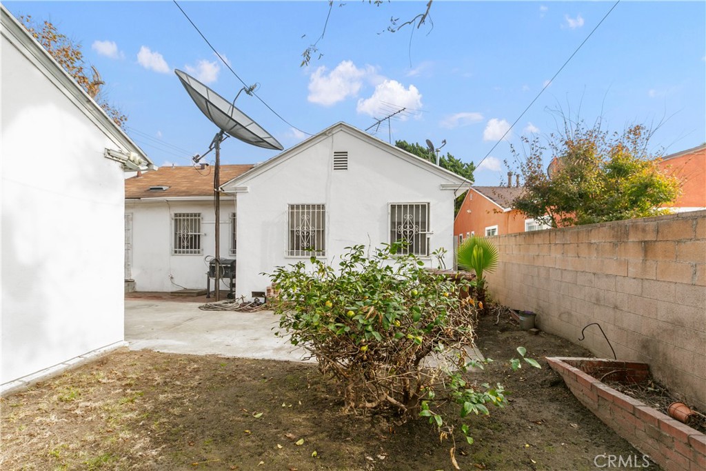 1615 North Van Ness Avenue Compton, CA 90221 - Photo 33 of 36 a yellow house with flower garden in front of it