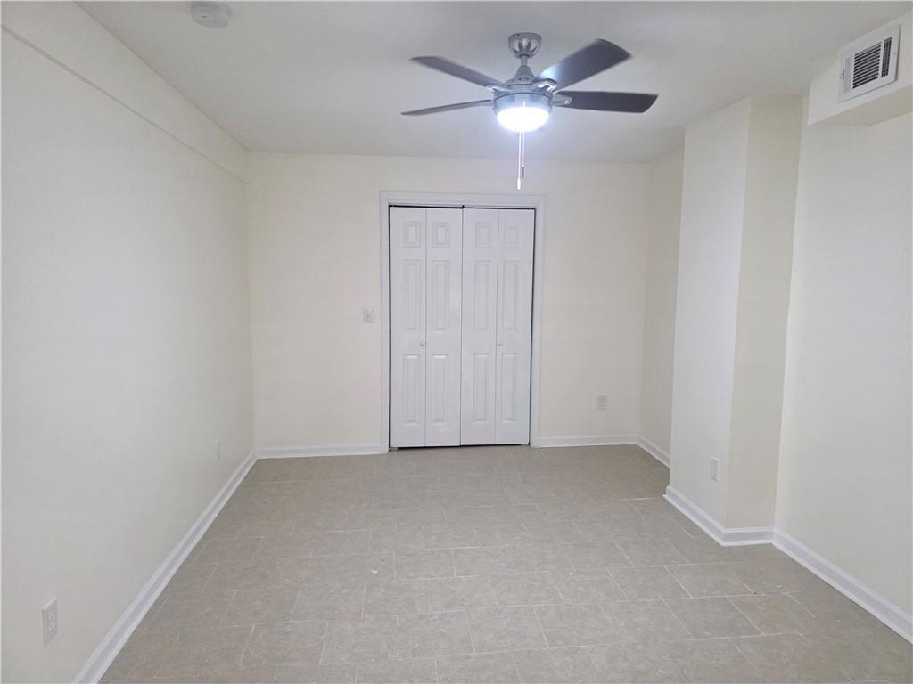 2435 Bouldercliff Way Southeast, Unit B Atlanta, GA 30316 - Photo 2 of 5 an empty room with a chandelier fan and windows