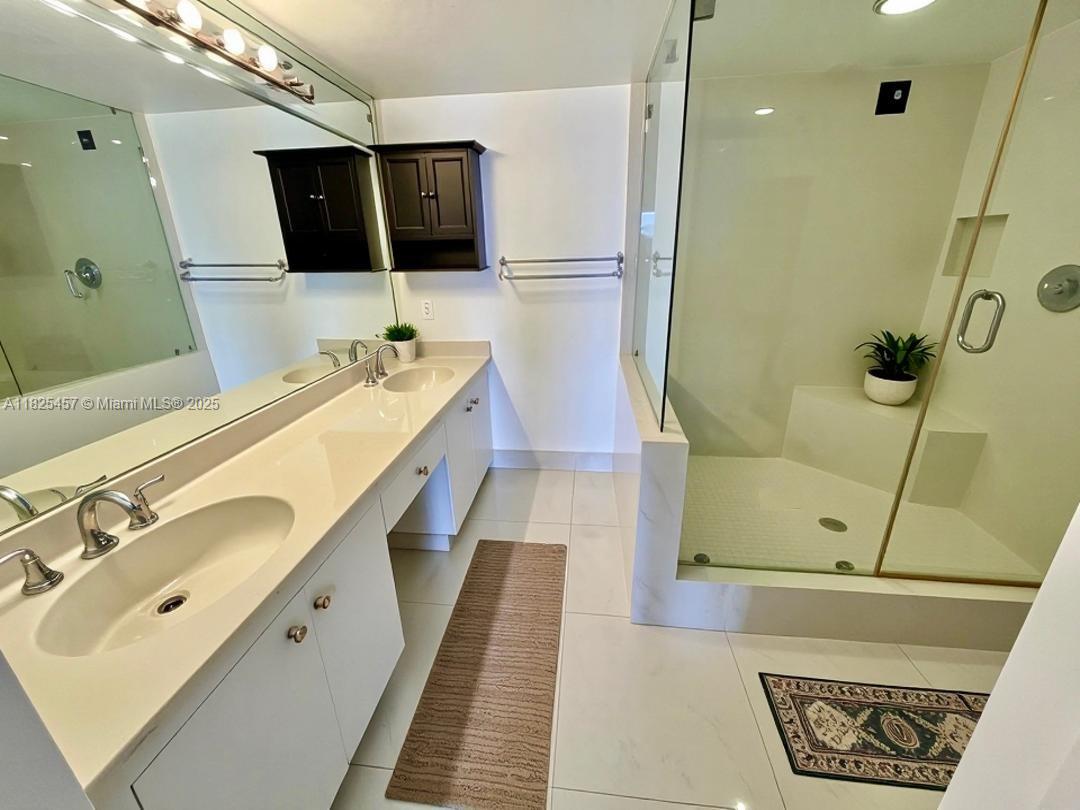 1000 Quayside Terrace, Unit 1009 Miami, FL 33138 - Photo 14 of 50 a bathroom with a sink a mirror and shower
