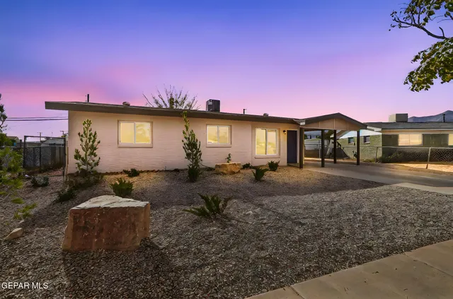 a view of a house with a yard and sitting area