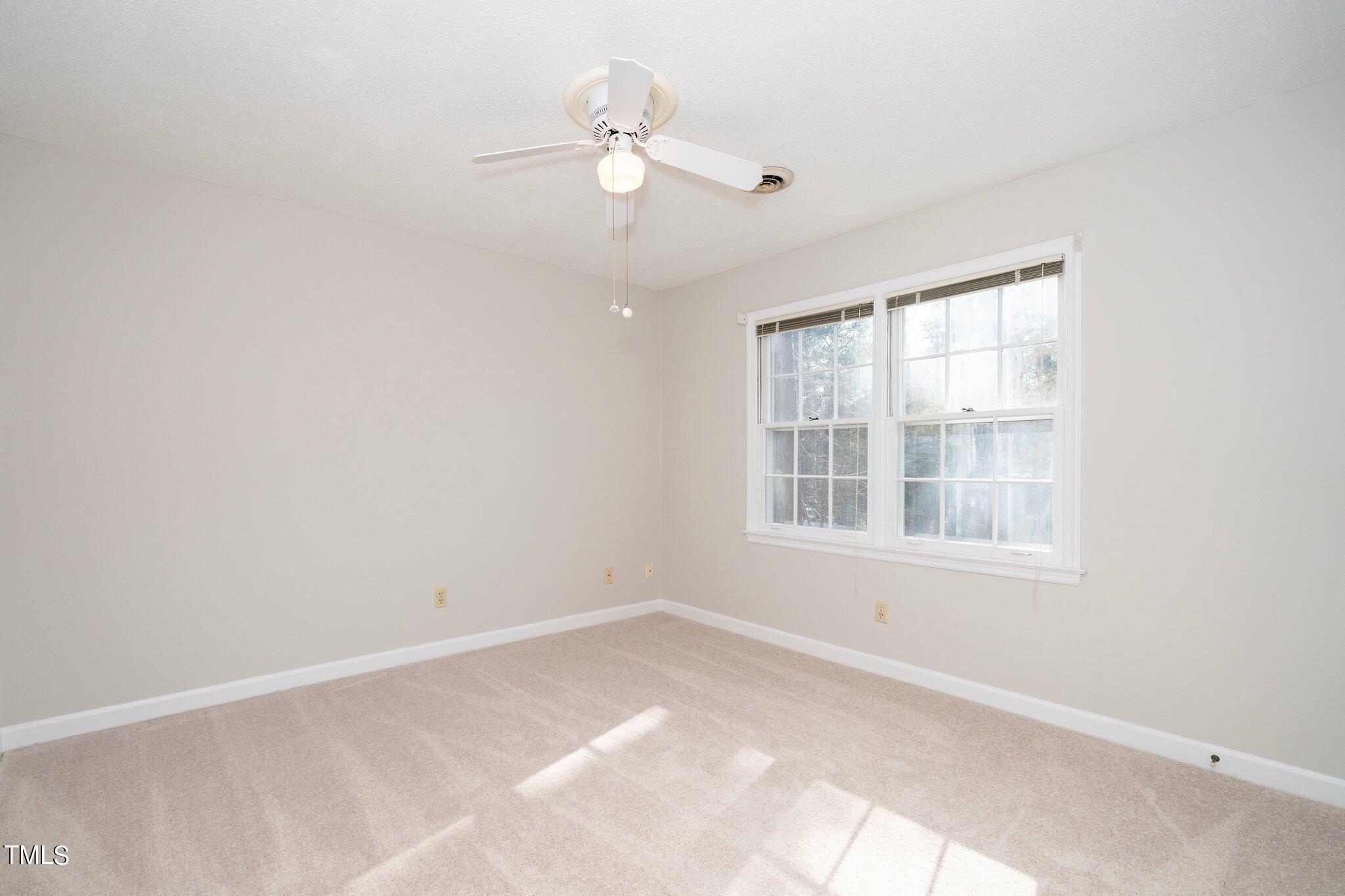 5705 Timber Ridge Drive Raleigh, NC 27609 - Photo 17 of 31 an empty room with chandelier fan and windows