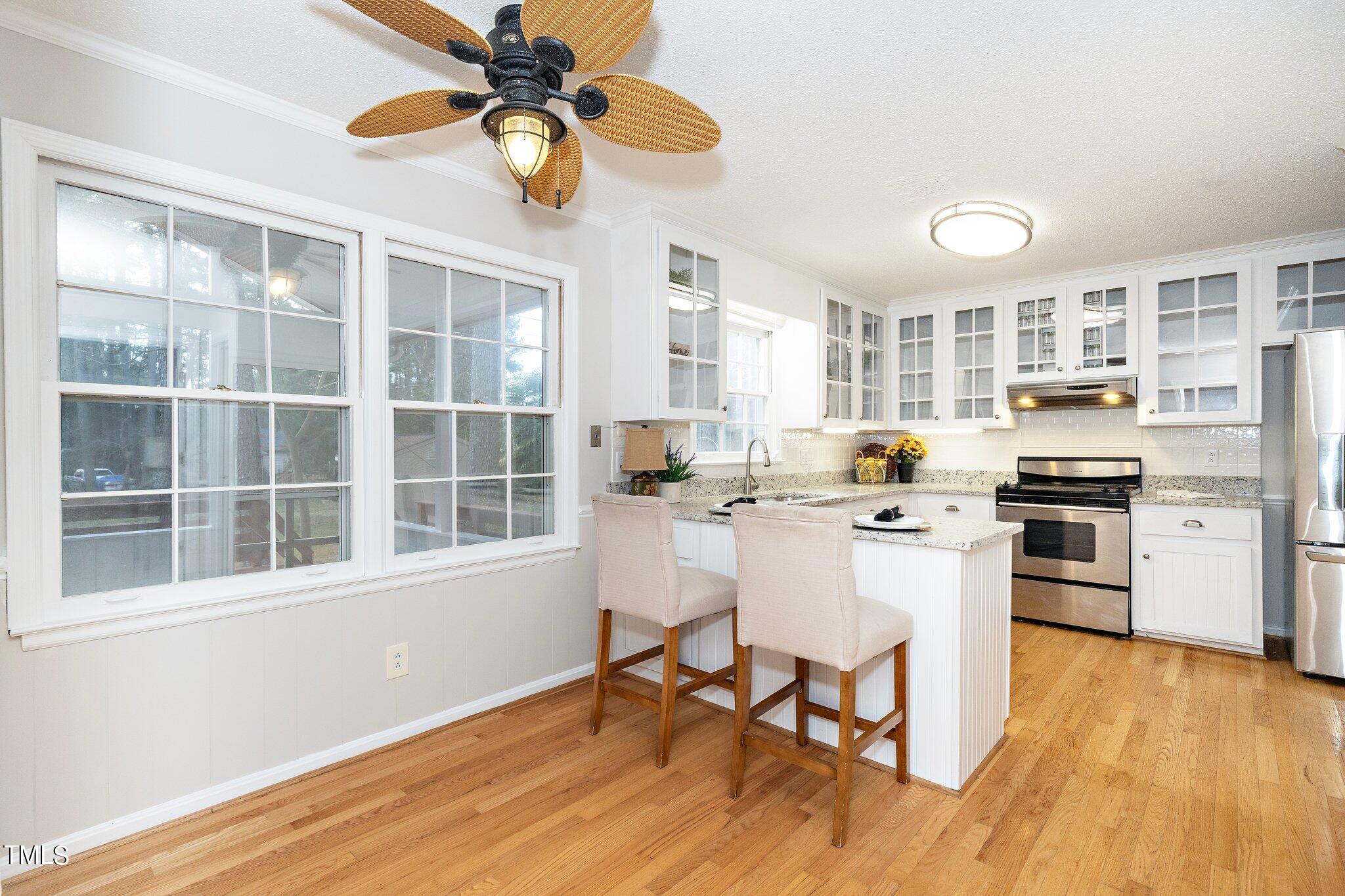 5705 Timber Ridge Drive Raleigh, NC 27609 - Photo 5 of 31 a kitchen with a stove a refrigerator and wooden floor