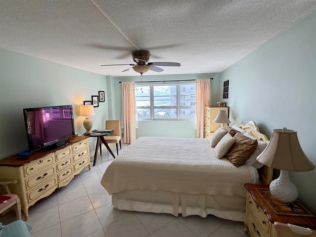 133 North Pompano Beach Boulevard, Unit 911 Pompano Beach, FL 33062 - Photo 12 of 21 a bedroom with furniture and a flat screen tv