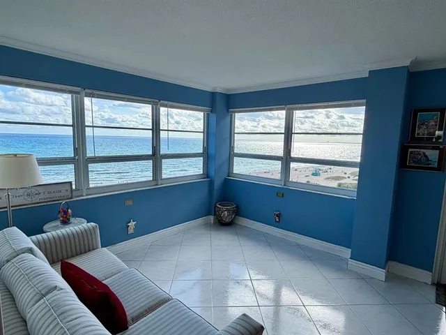 a living room with furniture and a floor to ceiling window