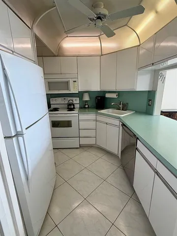 a kitchen with white cabinets and white appliances