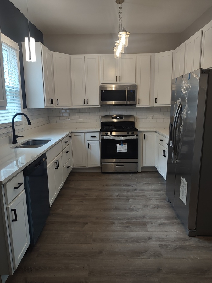 11531 South Perry Avenue Chicago, IL 60628 - Photo 3 of 16 a kitchen with stainless steel appliances a stove refrigerator sink and microwave