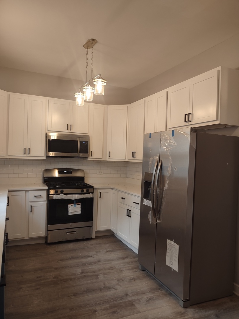 11531 South Perry Avenue Chicago, IL 60628 - Photo 4 of 16 a kitchen with stainless steel appliances a refrigerator sink and microwave