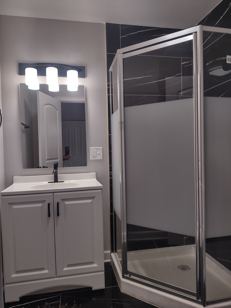 11531 South Perry Avenue Chicago, IL 60628 - Photo 8 of 16 a bathroom with a mirror and a shower