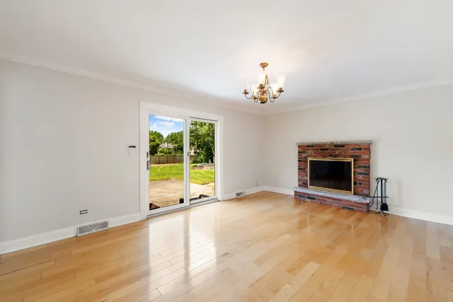 a view of an empty room with a fireplace and a window