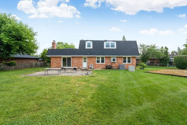 a front view of a house with a yard and trees
