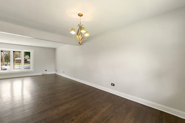 a view of a big room with wooden floor and chandelier