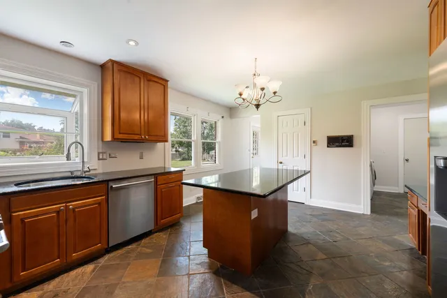 a large kitchen with kitchen island granite countertop a sink counter space and appliances