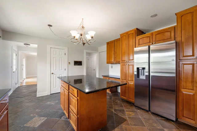 a kitchen with stainless steel appliances granite countertop a refrigerator a sink a stove and island